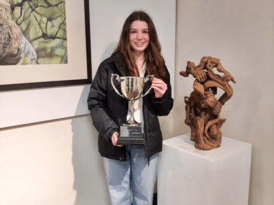 Pupil standing with trophy