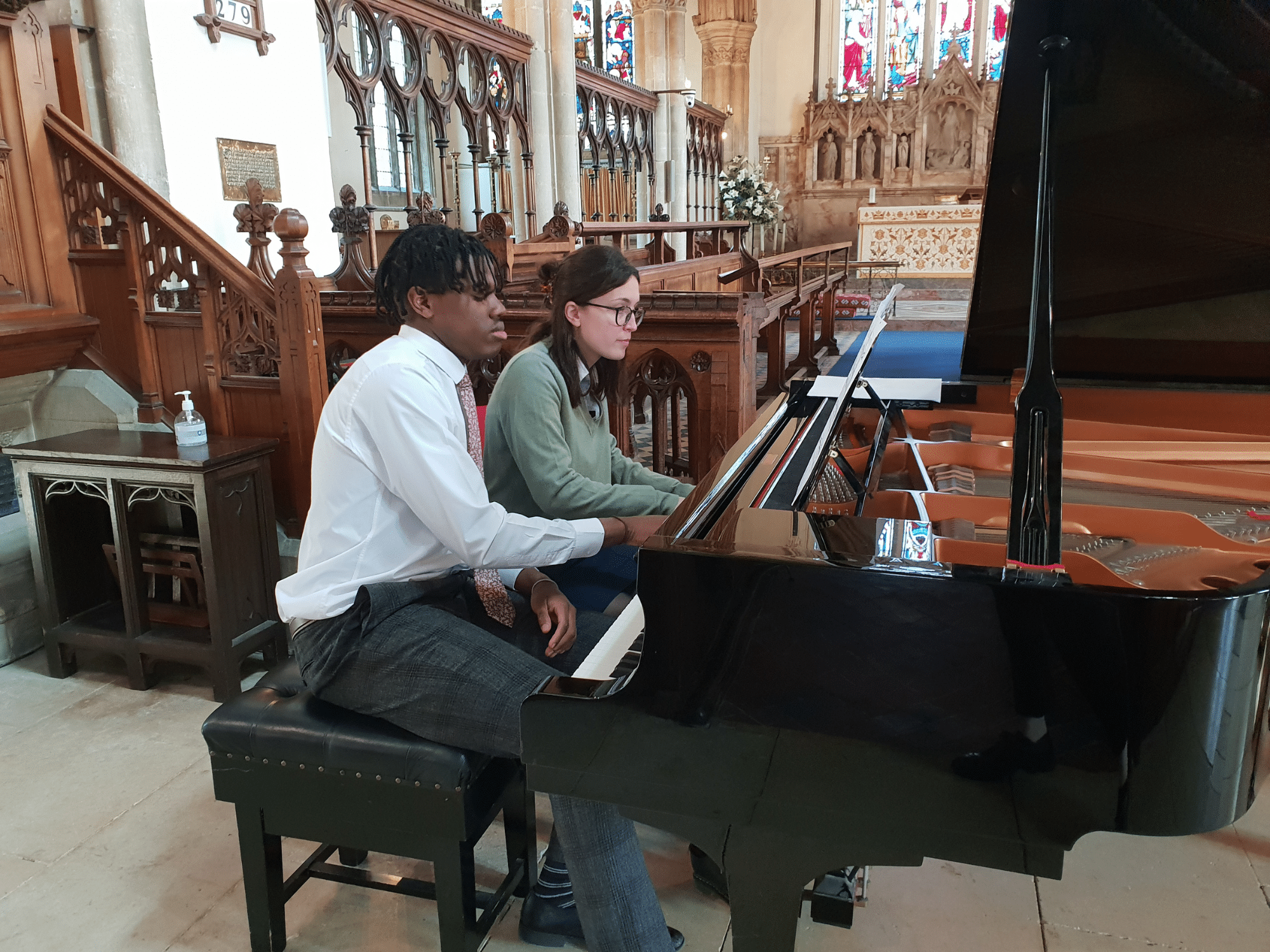 Two pupils perform a piano duet