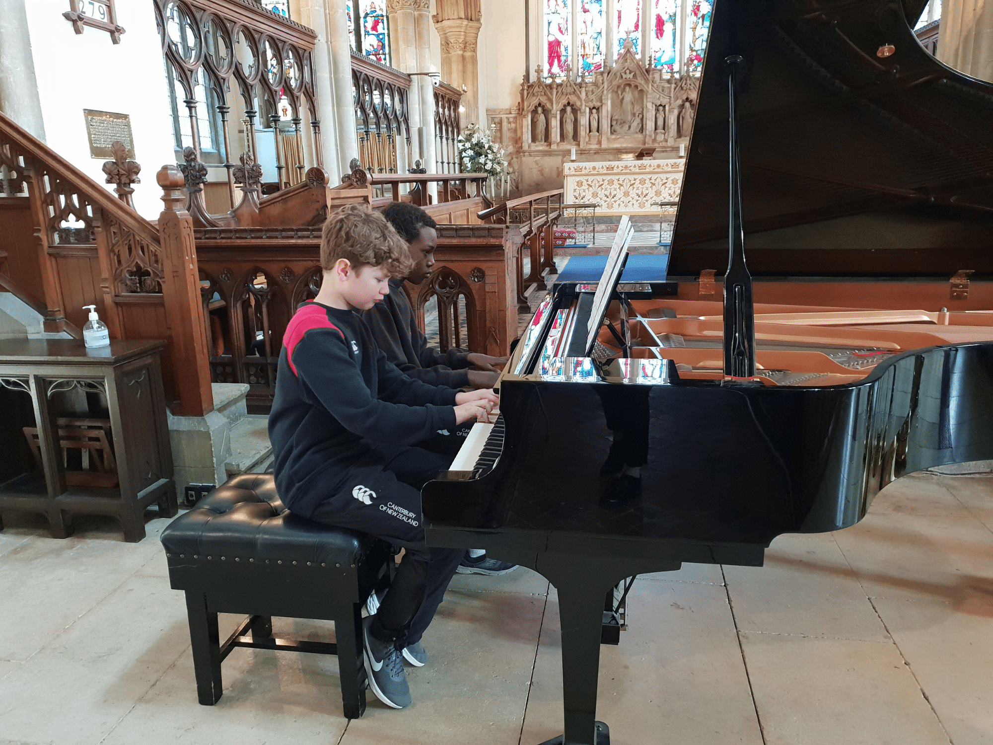 Two pupils perform a piano duet