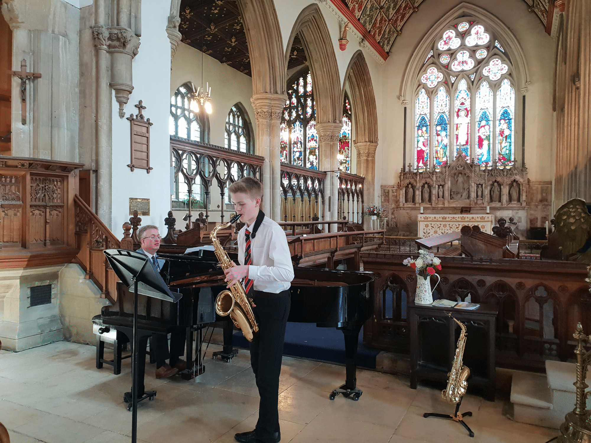 Student plays tenor sax in concert in church