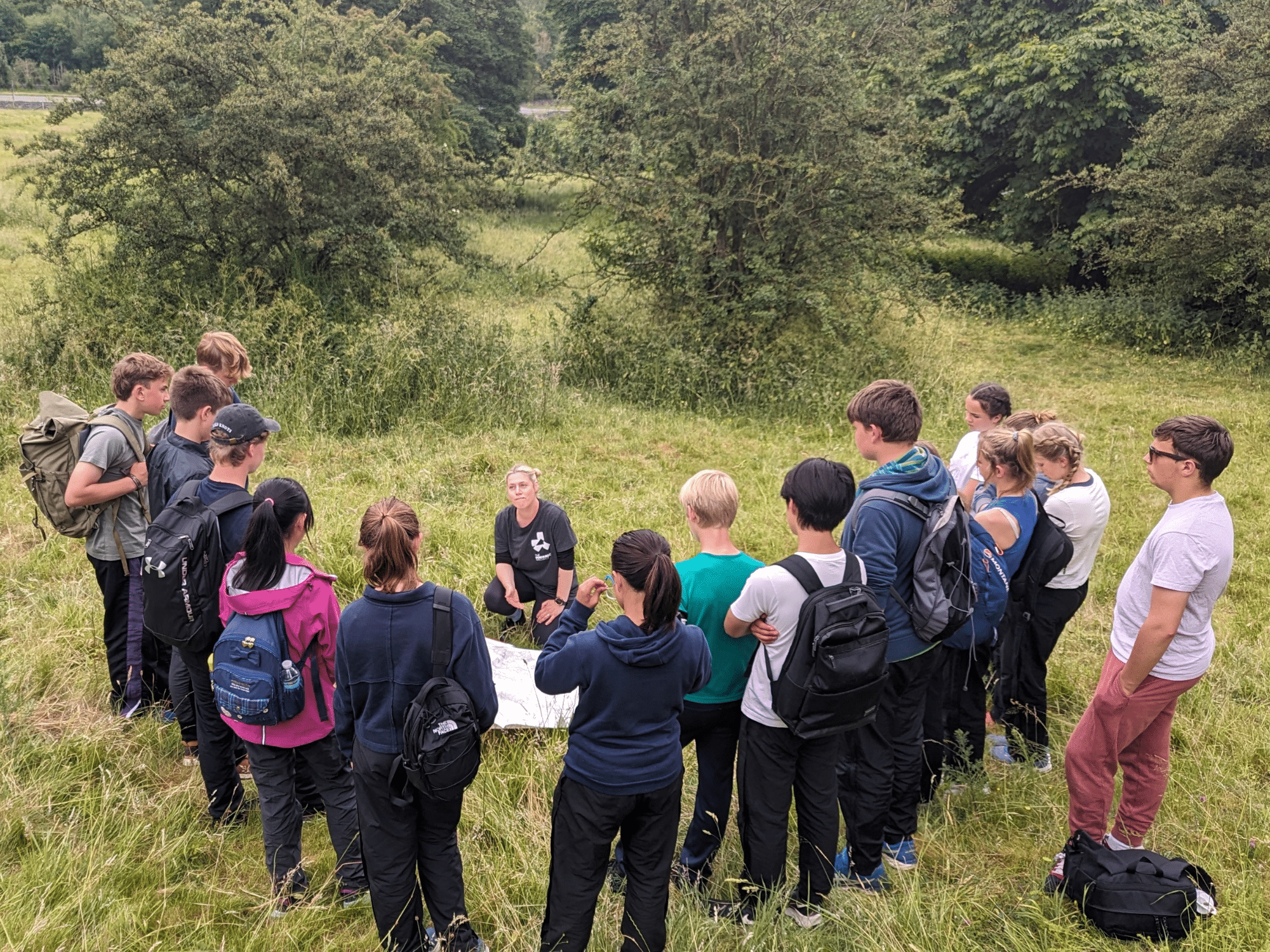 Pupils gathered around camp guide reading map